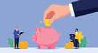 © Shakil - Personal finance and savings management concept showing a hand depositing a coin into a piggy bank near professional financial advisors.