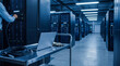 © Daniel - IT engineer performing maintenance on server racks in a large modern data center aisle with a laptop cart.