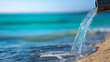 © Nataliya - Industrial pipe discharging waste water onto a beach, environmental pollution and water waste awareness concept, defocused background, with copy space