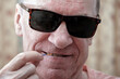 © Alex - A middle-aged man cleans between his teeth with a dental brush