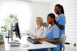 © Marko - Three healthcare professionals work together at a computer in a bright office setting