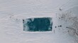 © LimeSky - drone flying above a tarp-covered pool in winter snow and cold