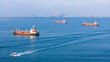 © Yellow Boat - LPG gas and oil tanker ships anchored in the ocean, with a fast patrol boat in the foreground. Global energy transport, war energy crisis, and Strait of Hormuz blockade concept.