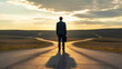 © Labib - Businessman Standing at a Fork in the Road at Sunset Representing Career Choice and Future Decision Making
