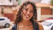 © Z A C - Young Woman with Curly Hair, Smiling at the Camera, in an Urban Environment.