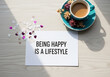 © Nusrat - Being happy is a lifestyle quote on wooden table with coffee cup and flowers