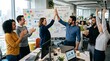 © Olga - A diverse team celebrates success in a modern office, giving high-fives and smiling around a desk with charts, laptops, and a whiteboard showing achieved goals and performance growth.