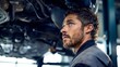 © Nick Freund - Kfz-Mechaniker arbeitet mit Werkzeug am Unterboden eines Fahrzeugs auf der Hebebühne