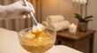 © Sugar Love Love - Gloved hand dipping brush into gold facial mask in luxury spa