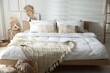 © New Africa - Large bed with clean linens and decor near white wall in bedroom. Interior design