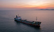 © Galeno - aerial photograph taken high angle calm bay golden hour weathered small cargo ship motion amidst vibrant orange
