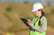 © STOCKEROcr - Female engineer wearing hard hat taking notes on tablet