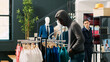 © DC Studio - African american robber trying to steal stylish clothes, being threatened with security baton buy asian bodyguard in modern boutique. Thief wearing sunglasses and hood not to be recognized