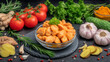 © Shahazadi - A bowl of cooked chicken is surrounded by fresh vegetables and herbs on a dark surface