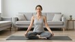 © Teerapol - Woman Practicing Yoga Meditation in Living Room Peaceful Atmosphere