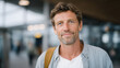 © forenna - Man in his late forties in airport arrivals holding a sign with no name, just his own name on it, subtle comment on job loss identity, creative documentary concept, solo traveler, white background t