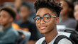 © syhin_stas - Young african american student with glasses and backpack smiling, looking at camera in classroom, representing education, learning, and future generation. Malcolm X Day