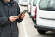 © scharfsinn86 - Fleet manager with digital tablet supervising rows of white delivery vans