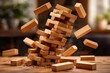 © AkuAku - falling wooden jenga tower with out of focus background scene