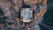 © Maksym - Historic American bridge cable anchorage aerial view showing massive concrete foundation with steel cables radiating across dramatic canyon landscape