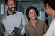 © Migma_Agency - Coworkers laughing cheerfully while discussing business in office