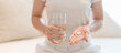 © Jo Panuwat D - woman hand holding medicine painkiller pill and water glass on the sofa at home, taking for headaches, stomach ache, Diarrhea Pain from food poisoning, Endometriosis, Hysterectomy and Menstrual