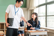 © buritora - A teacher and a female student using smartphones during class (BYOD/ICT)