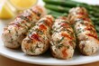 © Eduards V. - Grilled chicken breasts on a plate with fresh asparagus and lemon