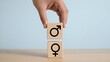 © Ch - Equality, gender symbols, wooden blocks, hand stacking, social issues concept