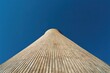 © Laba - A striking low-angle perspective captures the unique, curved architecture of a modern building against a vibrant, clear blue sky, emphasizing its geometric design and scale.