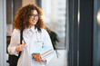 © Serhii - Female medical student smiling carrying books and stethoscope