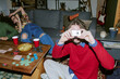© AnnaStills - Portrait of Caucasian young adult man holding compact camera and photographing friends during home game night, showing casual social bonding