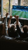 Group of friends cheering while watching a soccer match on TV