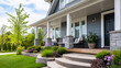 © Nataliya - Modern suburban house exterior with a welcoming porch, manicured lawn, and stone accents, curb appeal and real estate concept, home exterior photography, with copy space