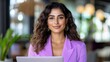 © Angellacelin - Confident Young Woman with Curly Hair Smiles at the Camera While Working on Her Laptop Indoors