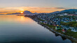 © AmazingAerialAgency - Aerial view of colorful houses along the rocky coastline at sunset with mountains in the distance Nuuk, Sermersooq Municipality, Greenland.