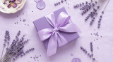 Purple gift box with satin ribbon and dried lavender flowers on linen background