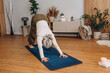 © sashafolly - Senior woman practices new yoga pose in bright home studio