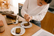 © Adrian Rodd/Stocksy - Woman decorating slices of freshly baked cake with a pastry bag