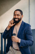 © Dimitrije Tanaskovic/Stocksy - Stylish man speaks on the phone outdoors