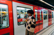 © DZ FILM/Stocksy - A woman using a mobile phone in the subway