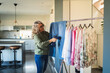© Diego Martin/Stocksy - Woman using handheld garment steamer on blue jeans at home