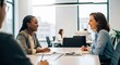 © soem - Two women are engaged in a lively conversation at a conference table. They are smiling and laughing, suggesting a positive and collaborative atmosphere.