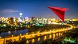 © bento - Red paper airplane flying above blurred city lights, vibrant urban nightscape reflecting creativity, imagination, and freedom, symbolizing playful innovation within modern environments of possibility.