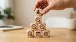 © Masque - A hand arranging wooden blocks in a pyramid structure for time management and productivity concepts.