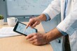 © Philipp - Man in white coat pointing at survival curve on tablet at table
