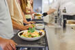 © Robert Kneschke - Students lined up in school cafeteria receiving freshly prepared nutritious meals