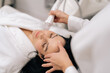 © dikushin - Close-up top view of relaxed woman receiving innovative rf microneedling facelift procedure from skilled esthetician, modern hardware cosmetology method for skin tightening and wrinkle reduction.