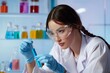 © olegganko - Young Scientist Examines Test Tube in Modern Laboratory During Research Experiment With Colored Liquids