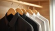 © hannn - Close-up of black and white shirts hanging in a wooden closet